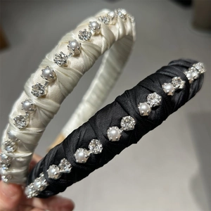 Detailed view of satin headbands with white faux pearls and sparkling rhinestones