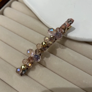 Detail of crystal hair clip with pink and purple beads on leopard print base
