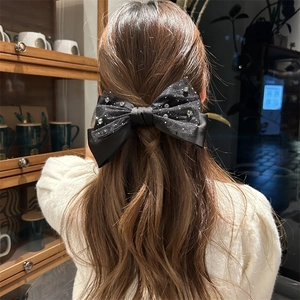 Detail einer eleganten schwarzen Organza-Schleifen-Haarklammer mit Strass auf der Frisur