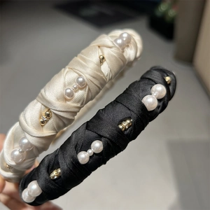 Detailed view of woven satin headbands featuring faux pearls and sparkling rhinestones