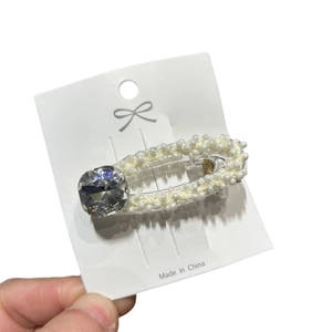 Elegante fermaglio per capelli ovale con perline e una gemma sfaccettata luccicante