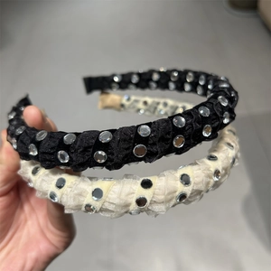 Detail of pleated fabric headbands in black and beige with sparkling round rhinestones