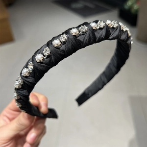 Detail showing hand-wrapped black satin headband with inlaid pearls and sparkling crystals