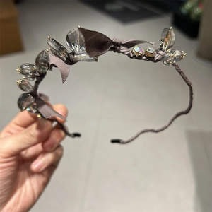 Macro shot of dark grey satin headband featuring sparkling multifaceted crystal beads