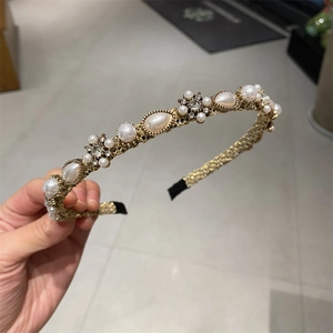Detail of gold metal headband with white pearls and sparkling crystal floral accents