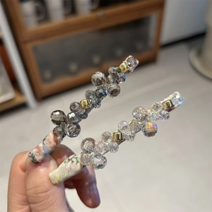 Macro shot of handmade beaded hair clips with floral fabric wrap and grey faceted crystals