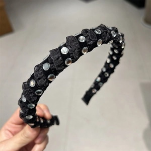 Detail of black pleated satin headband with sparkling round rhinestones for women