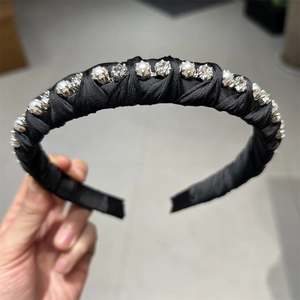 Detail of twisted black silk headband with sparkling crystals and imitation pearls