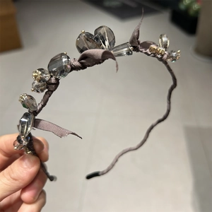 Detailed view of hand-wrapped dark brown satin headband with sparkling crystal beads