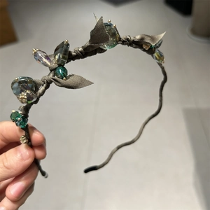 Detail of fairy-style hairband with emerald crystals and brown silk vine wrap