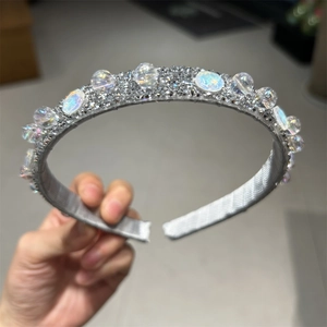 Dettaglio di un cerchietto grigio argento con strass scintillanti e perline colorate