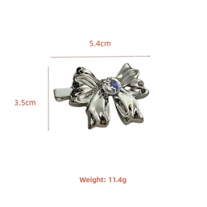 Silver bow hair clip with crystal center and wavy edges, size 5.4cm x 3.5cm