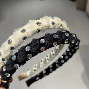 Detail showing pleated fabric headband with sparkling rhinestones in black and beige
