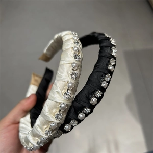 Detail of satin headbands with faux pearls and crystals in black and cream