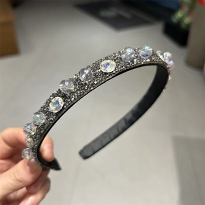 Cerchietto con cristalli luccicanti e perle iridescenti su una base nera chic