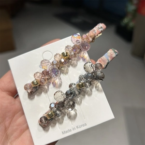 Close-up of handmade crystal bead hair clips with floral fabric and metallic accents