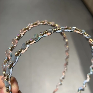 Détail d'un serre-tête floral avec perles mates carrées et strass brillants