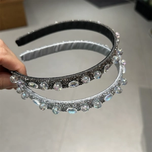 Dettaglio di due cerchietti di strass in nero e argento con grandi accenti di cristallo