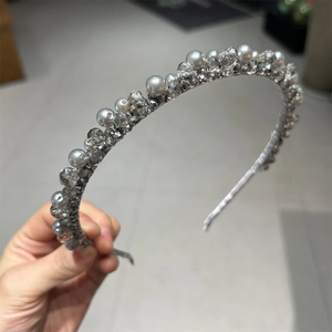 Detailed macro view of hand-wrapped crystals and pearls on a slim luxury headband