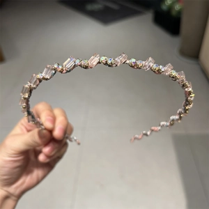 Détail d'un serre-tête perlé avec cristaux roses et perles arc-en-ciel sur métal
