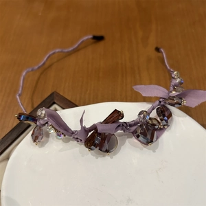 Detail of purple beaded headband with crystal accents and delicate ribbon bow detail