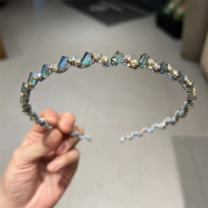 Détail d'un serre-tête fin avec cristaux bleu-vert et strass au style joaillerie