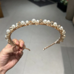 Detail of hand-wrapped white pearls and champagne crystal beads on a slim metal headband