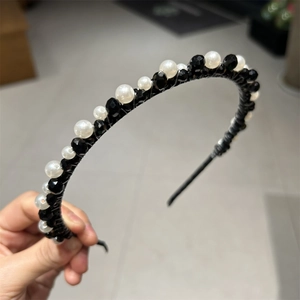 Detailed shot of handcrafted black crystals and pearls woven on a thin vintage headband
