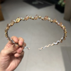 Gros plan de perles de cristal champagne et de strass sur un serre-tête délicat