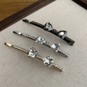 Detail view of crystal bow hair clips in black, silver and gold metal finishes