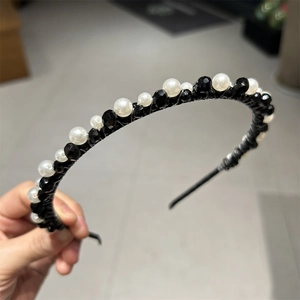 Macro detail of hand-woven headband with black faceted beads and white pearls