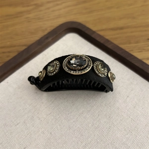Detail of vintage banana clip with black velvet and large grey crystal centerpiece