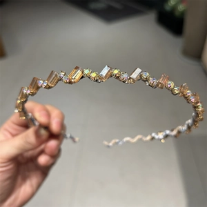 Détail d'un serre-tête ondulé orné de cristaux ambrés et de strass multicolores