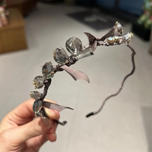 Close-up of silk headband with sparkling crystal beads and elegant ribbon bow detail