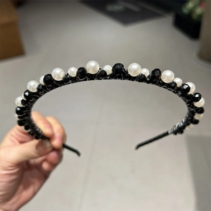 Close-up of handmade black and white beaded headband with crystal stones and pearls