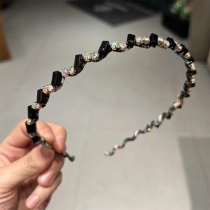 Détail du serre-tête ondulé avec perles carrées noires et strass brillants pour femme