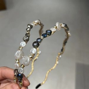 Detail of handmade crystal and pearl headband with gold wire wrap on metal base