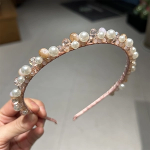 Detailed macro view of handmade crystal beads and white faux pearls on a slim metal headband