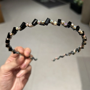 Détail du serre-tête avec perles géométriques noires et strass en cristal irisé