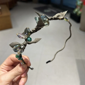 Detailed shot of handmade crystal headband with olive green bow and faceted clear stones
