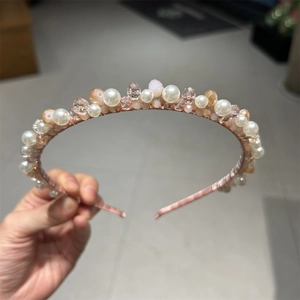 Detailed view of hand-woven rose gold headband with pearls and multifaceted crystals