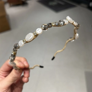 Elegant thin gold headband featuring crystals and pearls for a vintage aesthetic look