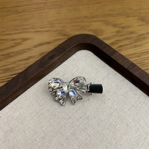Detailansicht der silbernen Haarklammer mit glitzernden Strasssteinen und schwarzem Clip
