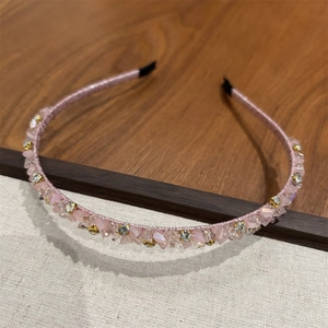 Détail montrant les pierres en cristal rose et les strass sur le serre-tête en tissu