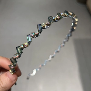 Détail d'un serre-tête fin orné de cristaux gris et de strass aurore boréale étincelants