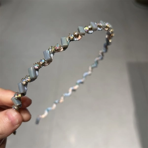 Détail du serre-tête ondulé bleu orné de perles en cristal gris et strass brillants