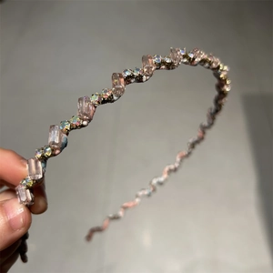 Détails de cristaux roses et strass brillants sur un serre-tête tissé pour femmes