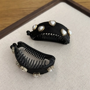 Detail of black banana clips with heart pearls and sparkling rhinestones for hair styling