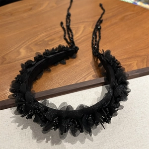 Detailansicht der schwarzen Netzblüten und Perlenquasten auf dem Vintage-Stirnband