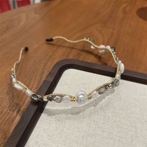 Detailed macro of crystal and pearl beaded headband with gold wire finish